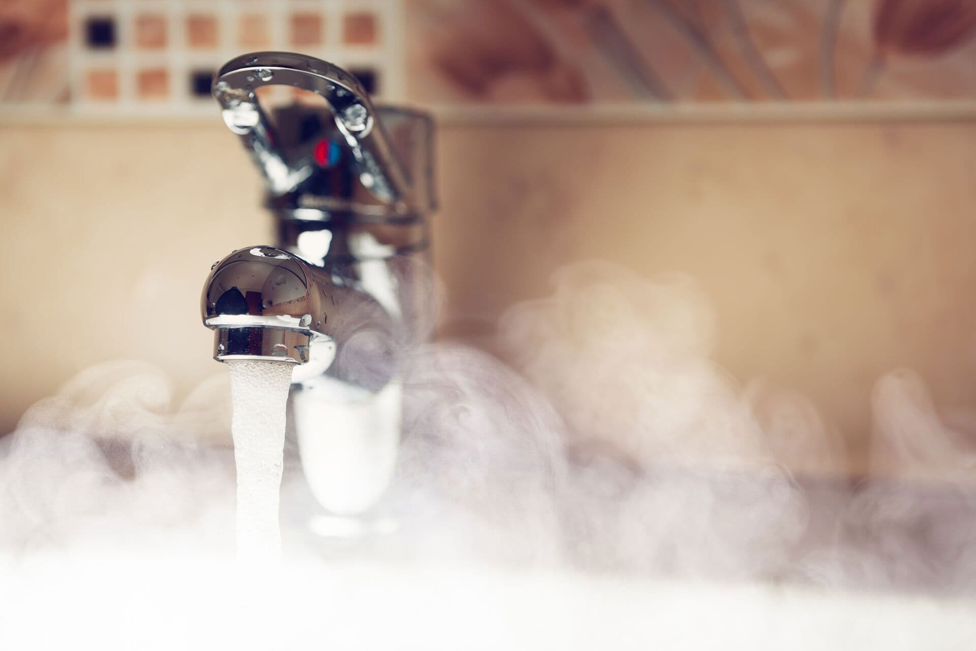 A faucet with steam rising from it, indicating hot water is flowing.