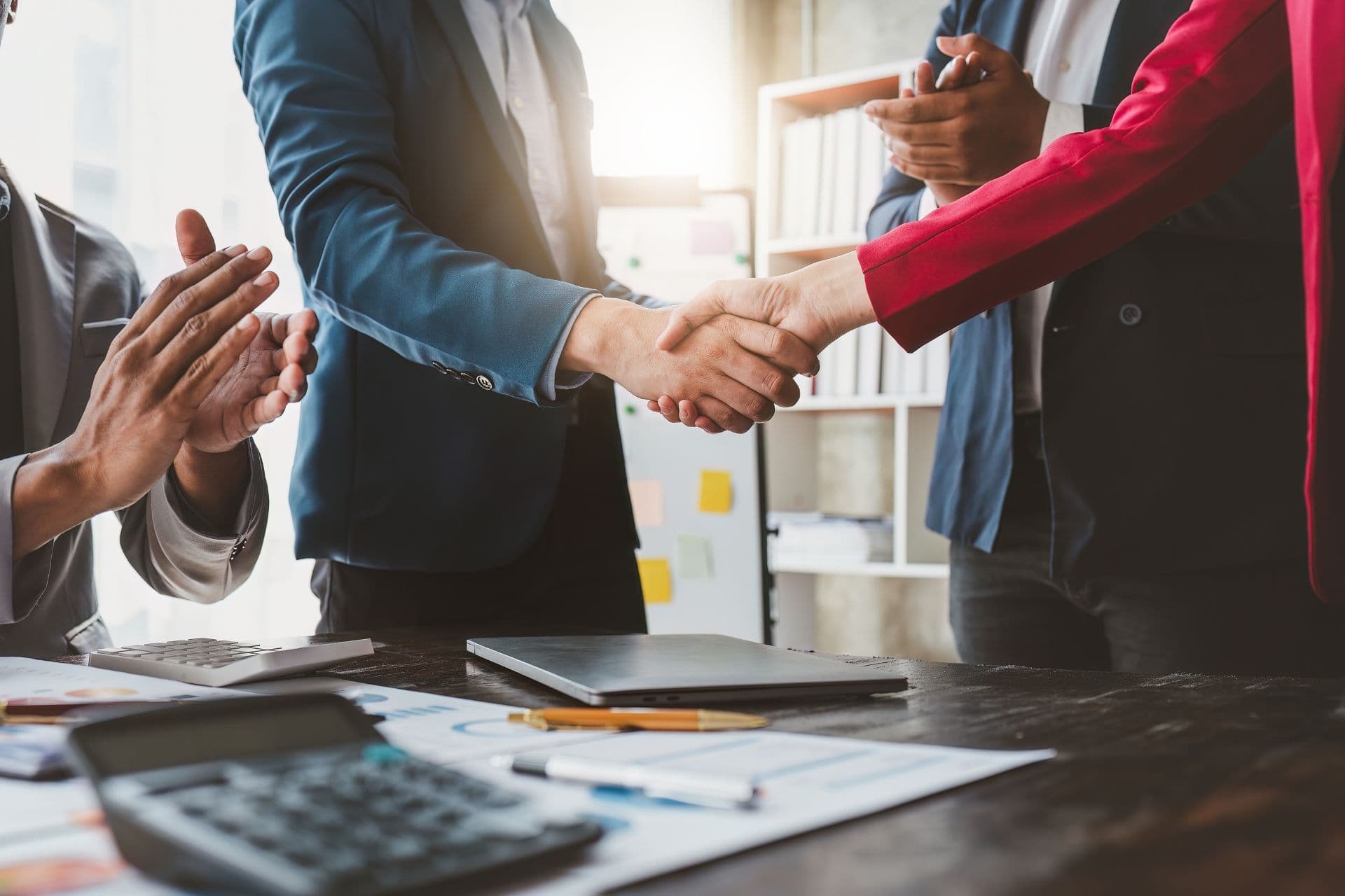 Successful businesspeople shaking hands after finishing a meeting and making a deal.