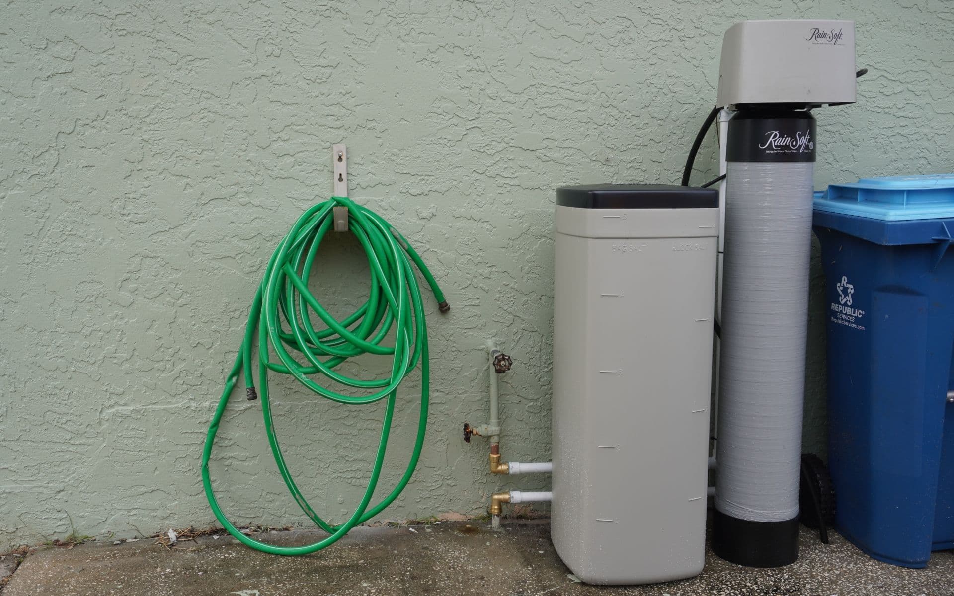 A newly-installed residential water treatment system and hose.