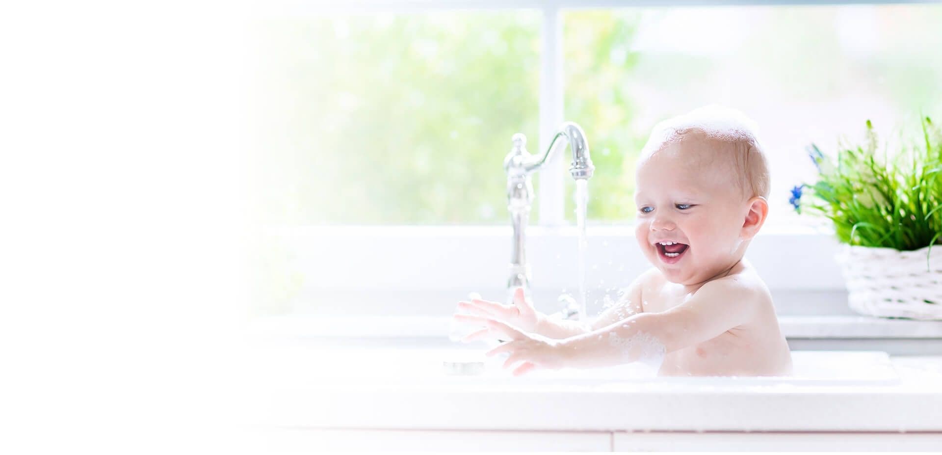 A child bathes in a sink.